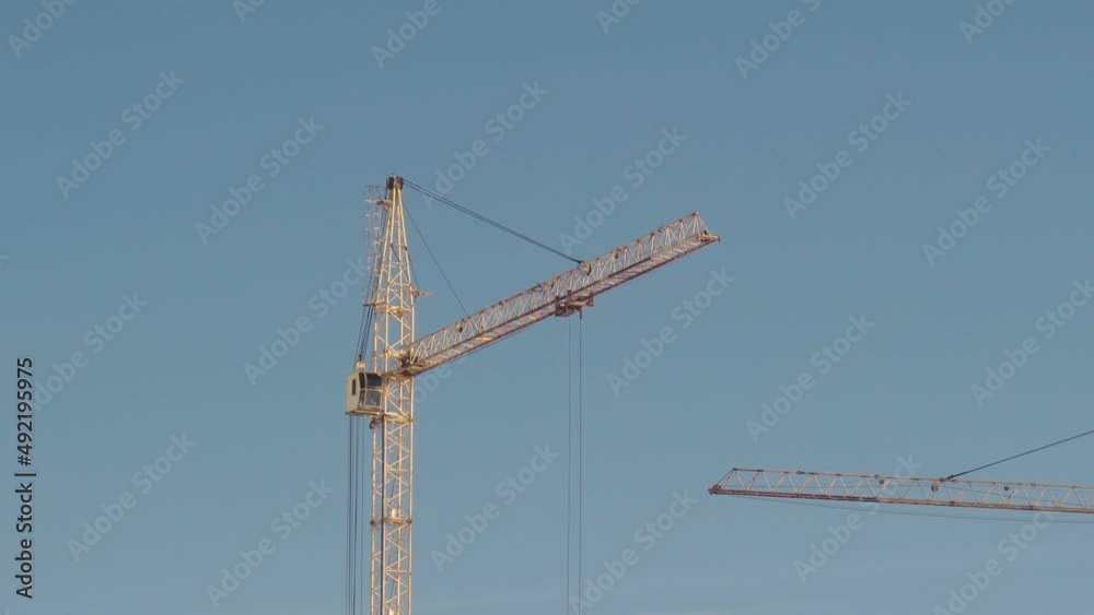 A construction crane on a blue sky background. A construction crane on a blue sky background.