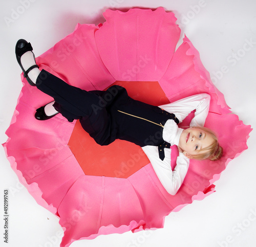 a little girl is lying in a big flower