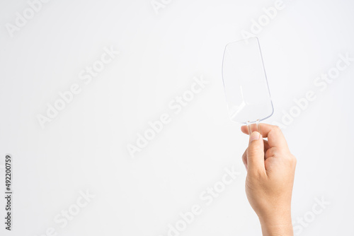 Hand holding small transparent plastic ice scoop for food