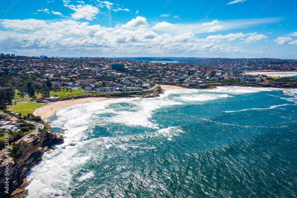 Aerial drone view of iconic Bronte Beach and Tamarama Beach coastline in Sydney, Australia during summer on a sunny day  