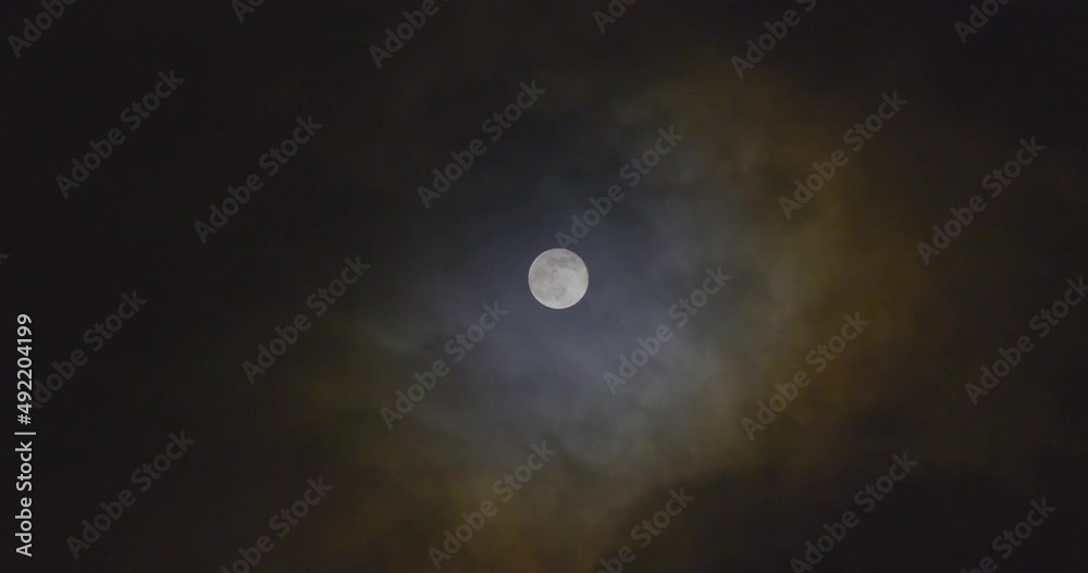 Full moon and windblown nebula looking clouds in the night sky. Full moon and windblown nebula looking clouds in the night sky.