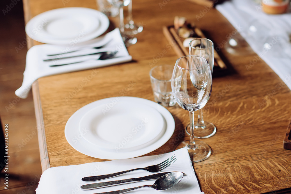 Classic wedding table setting on a wooden table. Dining setting Classic wedding table setting on a wooden table. Dining setting