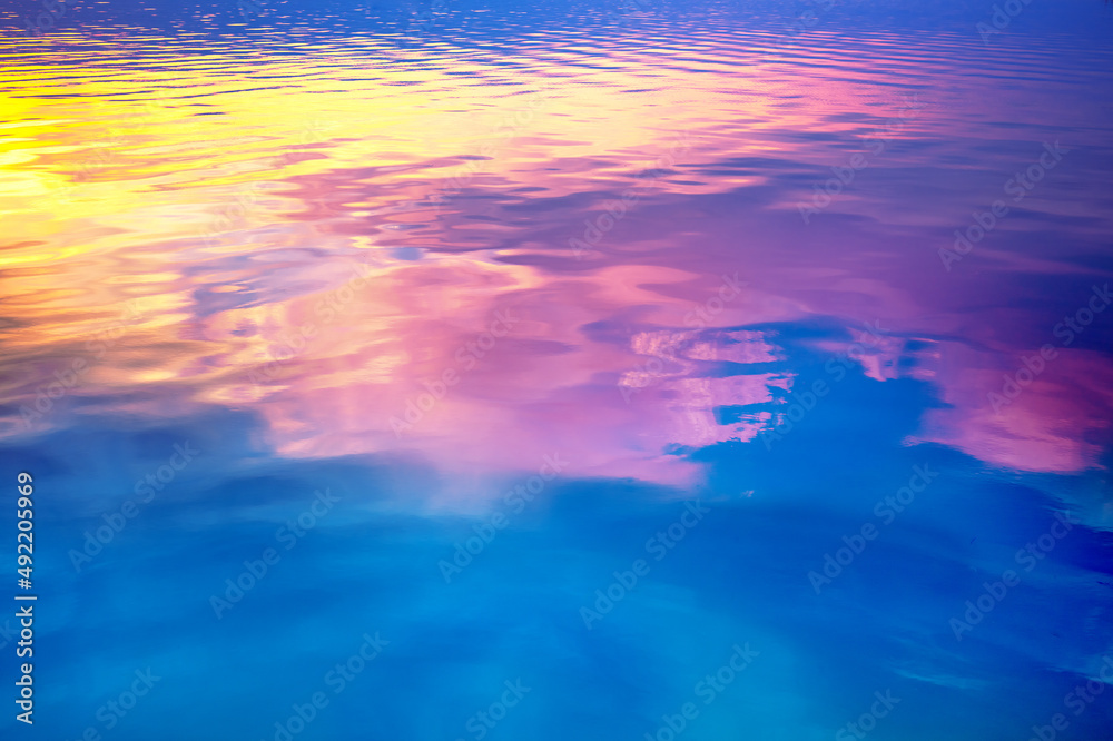Seascape at sunset light. Calm sea water with clouds and sun reflection. Abstract nature landscape background. Gradient color