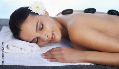 This feels like heaven. A beautiful woman receiving a hot stone massage.