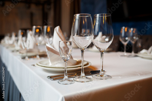 Serving a festive table in a restaurant. Preparation of a banquet for a holiday. Expensive decoration materials. Dishes for food and drinks