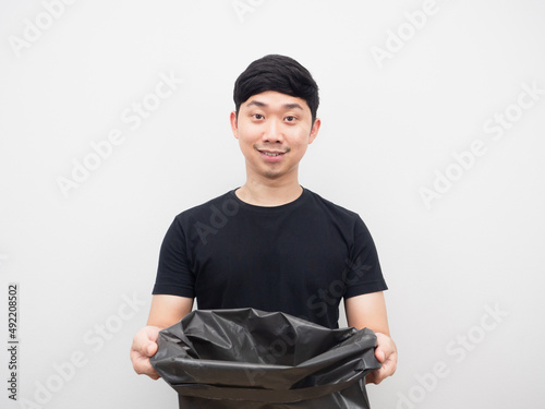 Asian man holding garbage bag with smiling portrait white background