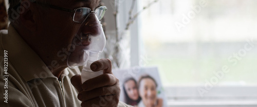 close-up of an old man doing inhalation photo