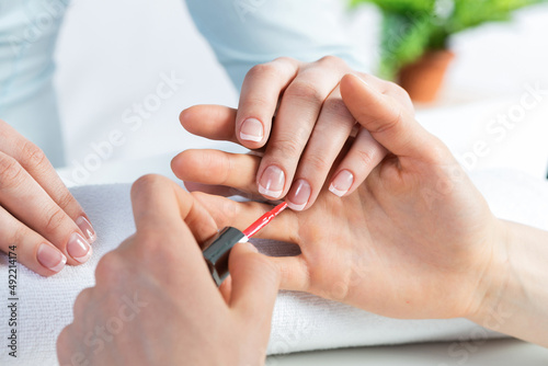Manicurist working with client's nails at table