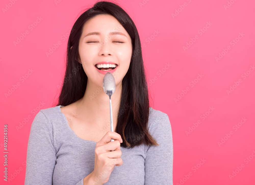 Happy and hungry lady hold metal spoon in mouth desire dinner think of tasty food Happy and hungry lady hold metal spoon in mouth desire dinner think of tasty food