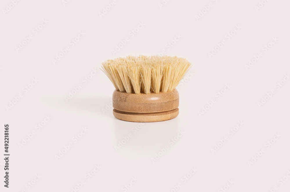 A natural bamboo dish brush on a light background. A zero waste, environmentally friendly alternative to plastic. A natural bamboo dish brush on a light background. A zero waste, environmentally friendly alternative to plastic.