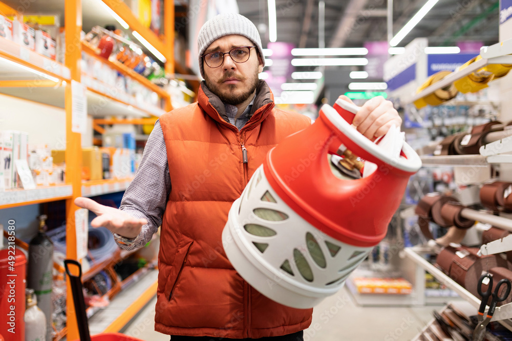 Fototapeta premium a man can't sort out a hardware store with a domestic gas bottle
