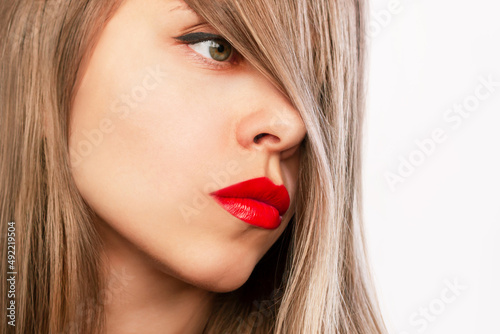 Cropped shot of a young attractive caucasian blonde woman with glossy red color lipstick on her lips isolated on a white background. Beauty and fashion concept