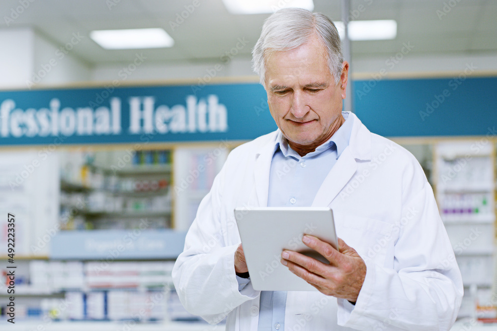 Always making sure were stocked on everything you need. Shot of a senior male pharmacist doing some work on his digital tablet. Always making sure were stocked on everything you need. Shot of a senior male pharmacist doing some work on his digital tablet.