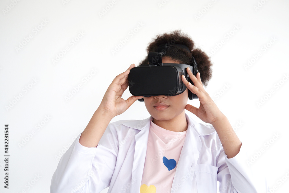 Smiling African doctor woman is relaxing with Virtual Reality glasses box. Student and pupil girl is learning technology and playing 4D online digital game. Education and technology Concept. Smiling African doctor woman is relaxing with Virtual Reality glasses box. Student and pupil girl is learning technology and playing 4D online digital game. Education and technology Concept.