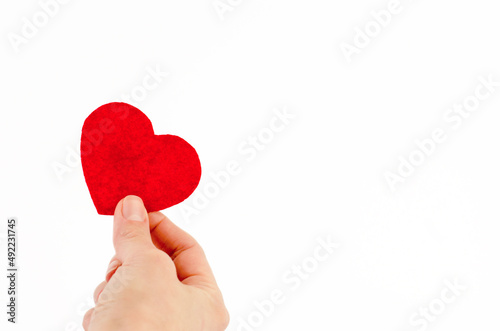 Small red heart in a female hand on a white background  copy space