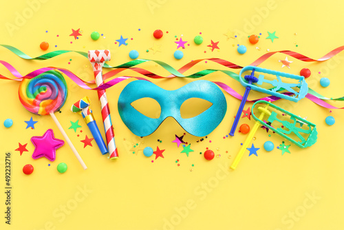 Purim celebration concept (jewish carnival holiday) over yellow background