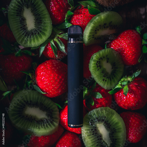 Disposable electronic cigarettes of different flavors over different fruits on the background. The concept of modern smoking, vaping and nicotine.