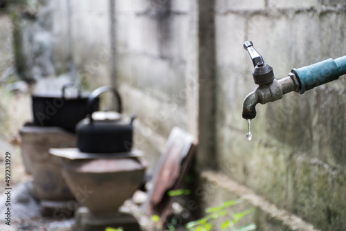 Old faucet with water leaking drop to the ground