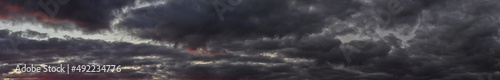 Panorama of a gloomy sky covered with dark clouds at sunset