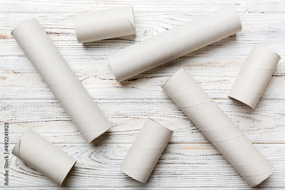 Empty toilet paper roll on colored background. Recyclable paper tube with metal plug end made of kraft paper or cardboard Empty toilet paper roll on colored background. Recyclable paper tube with metal plug end made of kraft paper or cardboard
