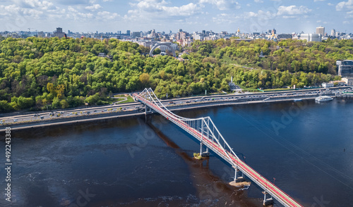 Kyiv city skyline and Dnipro river aerial drone view from above  Kiev hills  pedestrian Park bridge and Dnieper river cityscape in spring  Ukraine