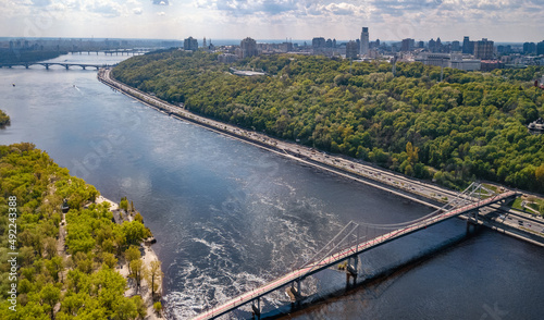 Kyiv city skyline and Dnipro river aerial drone view from above, Kiev hills, pedestrian Park bridge and Dnieper river cityscape in spring, Ukraine