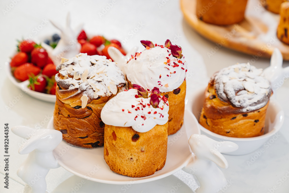 decorated panettones and cruffins on serving plates with rabbits. easter cakes. 