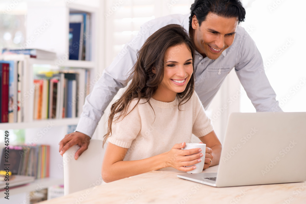 Looking through some of their honeymoon photos.... A husband and wife browsing the internet together indoors. Looking through some of their honeymoon photos.... A husband and wife browsing the internet together indoors.