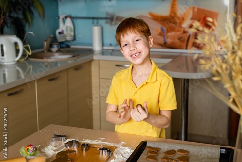 Preparing for Easter baking. Portrait of a child looking at the camera and smiling red-haired boy makes dough for baking cookies. Easter food concept