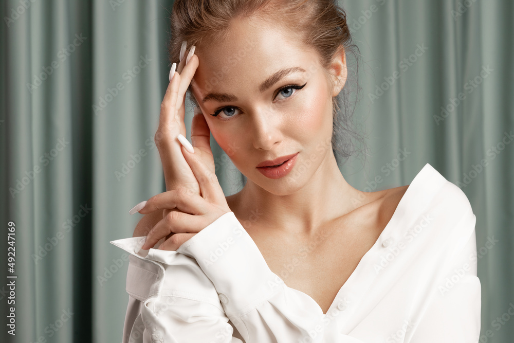 Alluring young female with perfect make up, smooth skin posing on curtain background. Pretty sensual caucasian woman advertising skincare treatment cosmetics. Natural womens beauty concept. Alluring young female with perfect make up, smooth skin posing on curtain background. Pretty sensual caucasian woman advertising skincare treatment cosmetics. Natural womens beauty concept.