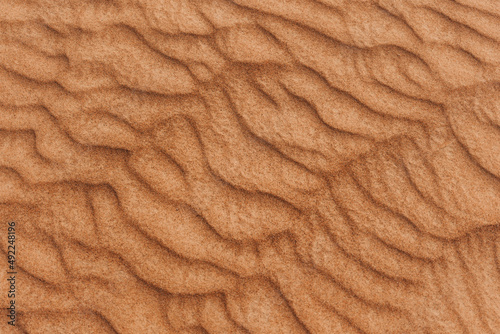 Texture of the sand in the desert. Wavy sand background. Top view