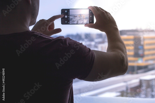 man holding a smartphone and taking a picture with it