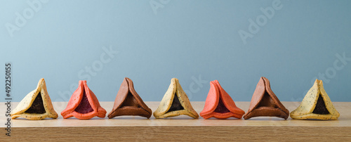 Jewish holiday Purim concept with colorful hamantaschen cookies on wooden table