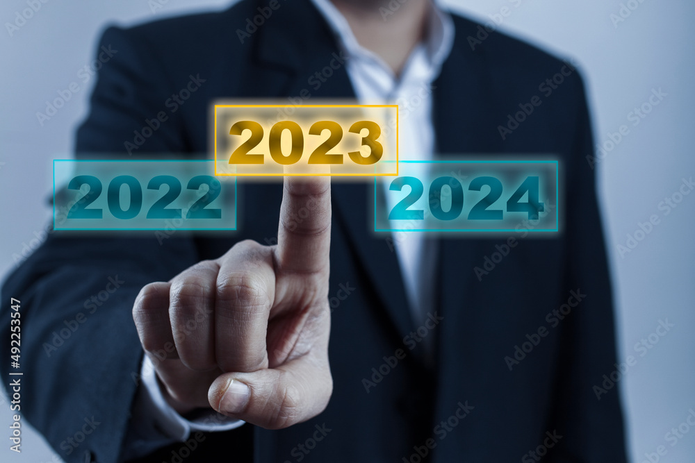 hand touching on 2023 calender year on digital screen hand touching on 2023 calender year on digital screen