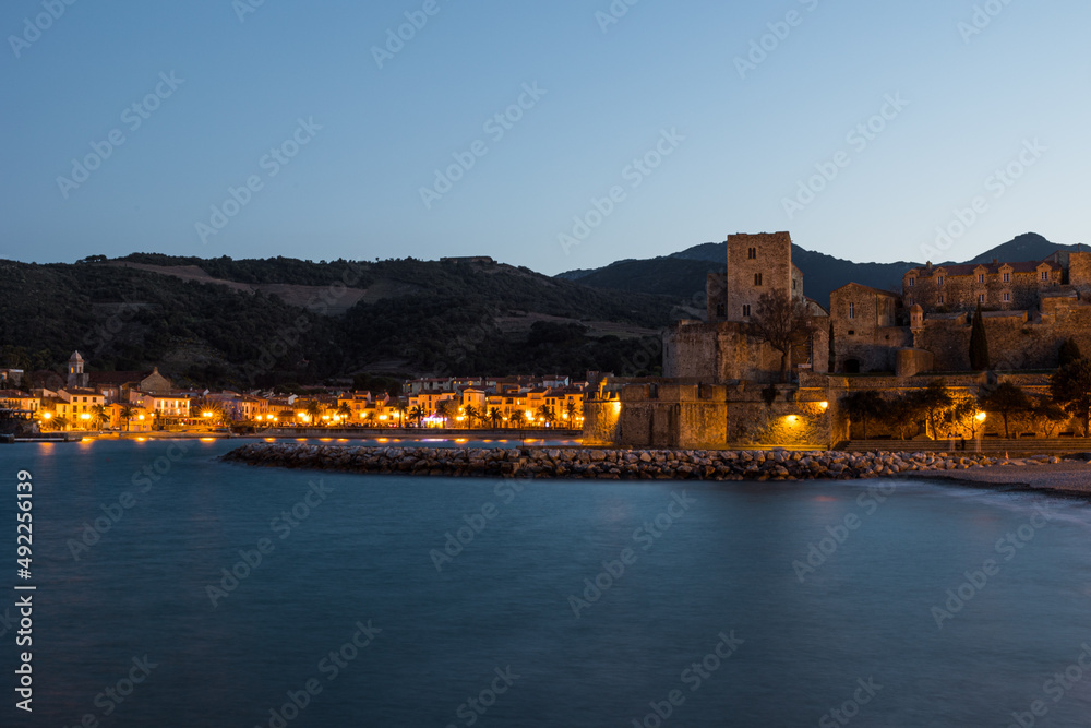 Vue au coucher de la nuit sur la Plage du Port d’Avall et le Château Royal de Collioure (Occitanie, France)