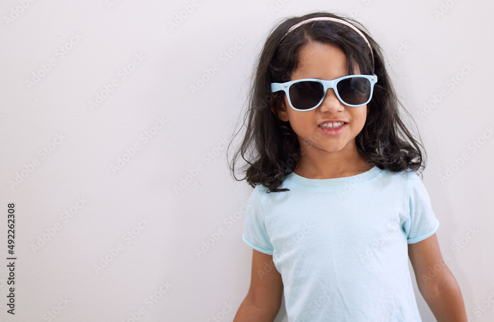 Mom says Im the coolest kid on the block. Shot of an adorable little girl wearing sunglasses while standing against a wall. Mom says Im the coolest kid on the block. Shot of an adorable little girl wearing sunglasses while standing against a wall.