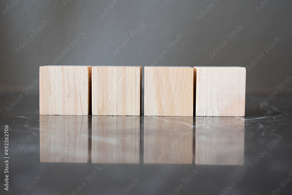 Tower of four wooden cubes on neutral background with copy space Tower of four wooden cubes on neutral background with copy space
