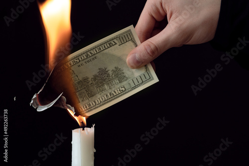 dollar inflation concept, 100 dollars banknote burns in fire, US currency depreciation photo