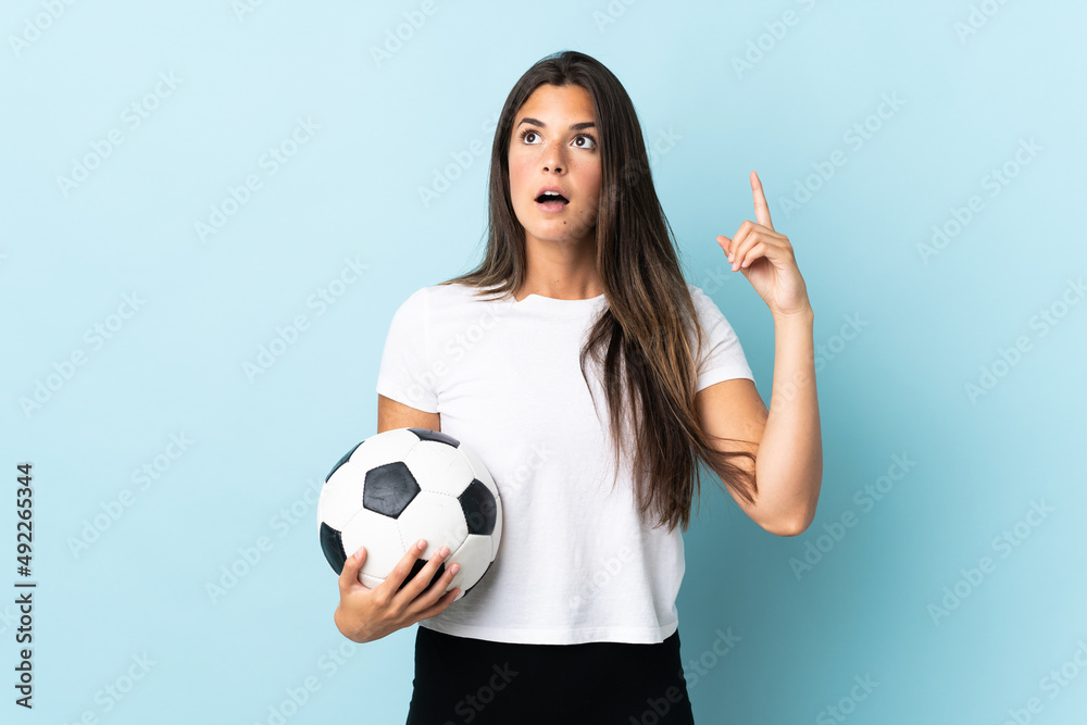 Young football player brazilian girl isolated on blue background thinking an idea pointing the finger up Young football player brazilian girl isolated on blue background thinking an idea pointing the finger up