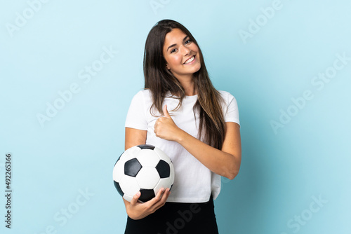 Young football player brazilian girl isolated on blue background giving a thumbs up gesture © luismolinero