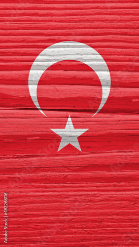 Turkish Flag on a dry wooden surface. Natural mobile phone wallpaper. Background made of old wood. The official symbol of Turkey. Solar lighting with hard shadows