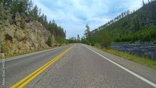 POV Driving a car on asphalt road heading to Yellowstone National Park in Montana.