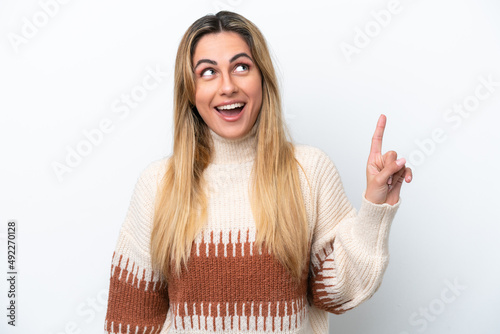 Young caucasian woman isolated on white background pointing up and surprised © luismolinero
