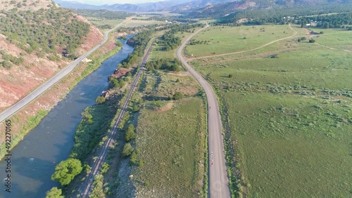 Runners on a mountain road by a river, aerial view in USA