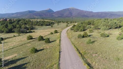 Aerial of woman running on rural mountain road in USA