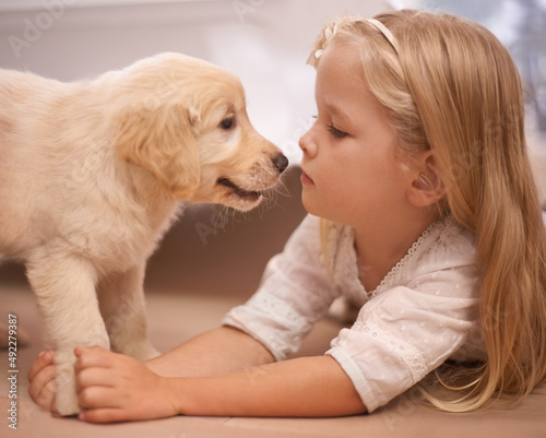 The best friend you can get. An adorable little girl with her puppy at home.