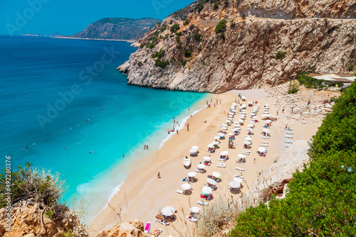 Aerial View From Flying Drone Of People Crowd Relaxing On Beach. Swimming people in sea. Top view of Kaputas Beach between Kas and Kalkan