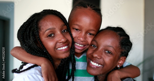 Little brother and steen sisters embrace. Black African ethnicity children photo