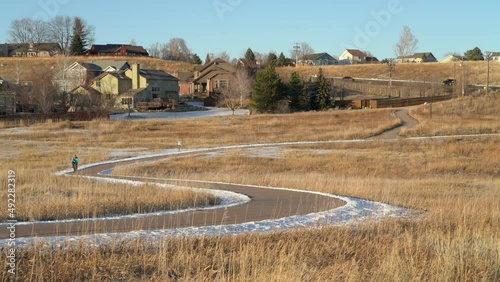 senior male cyclist is riding a gravel bike on a meandering bike trail, winter afternoon in Cathy Fromme Prairie Natural Area in Fort Collins, Colorado photo