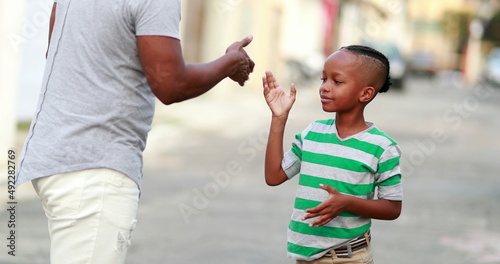 Little boy doing handshake with father. African ethnicity